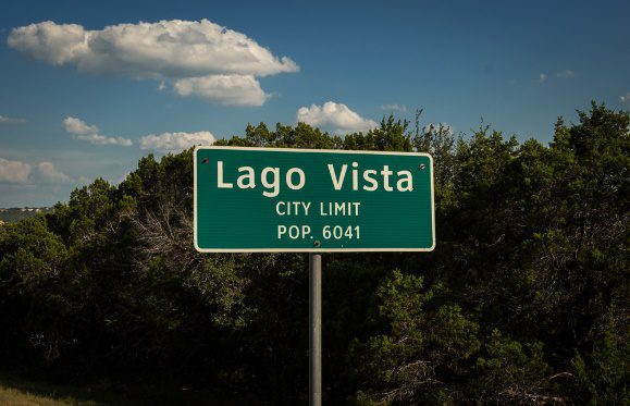 A close up of a street sign with trees in the background Description automatically generated