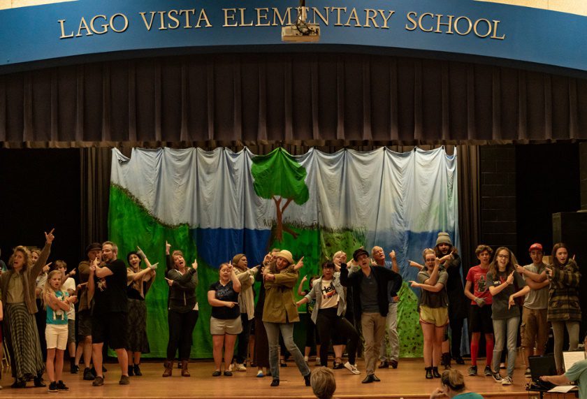 A group of people standing in front of a crowd Description automatically generated